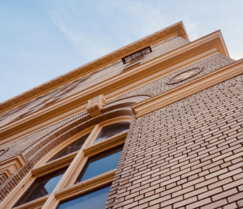Photo of detail of building from below against a blue sky  