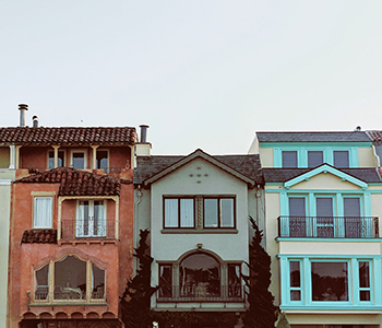 Photo of three colorful houses // Liz Sanchez Vegas / unsplash.com