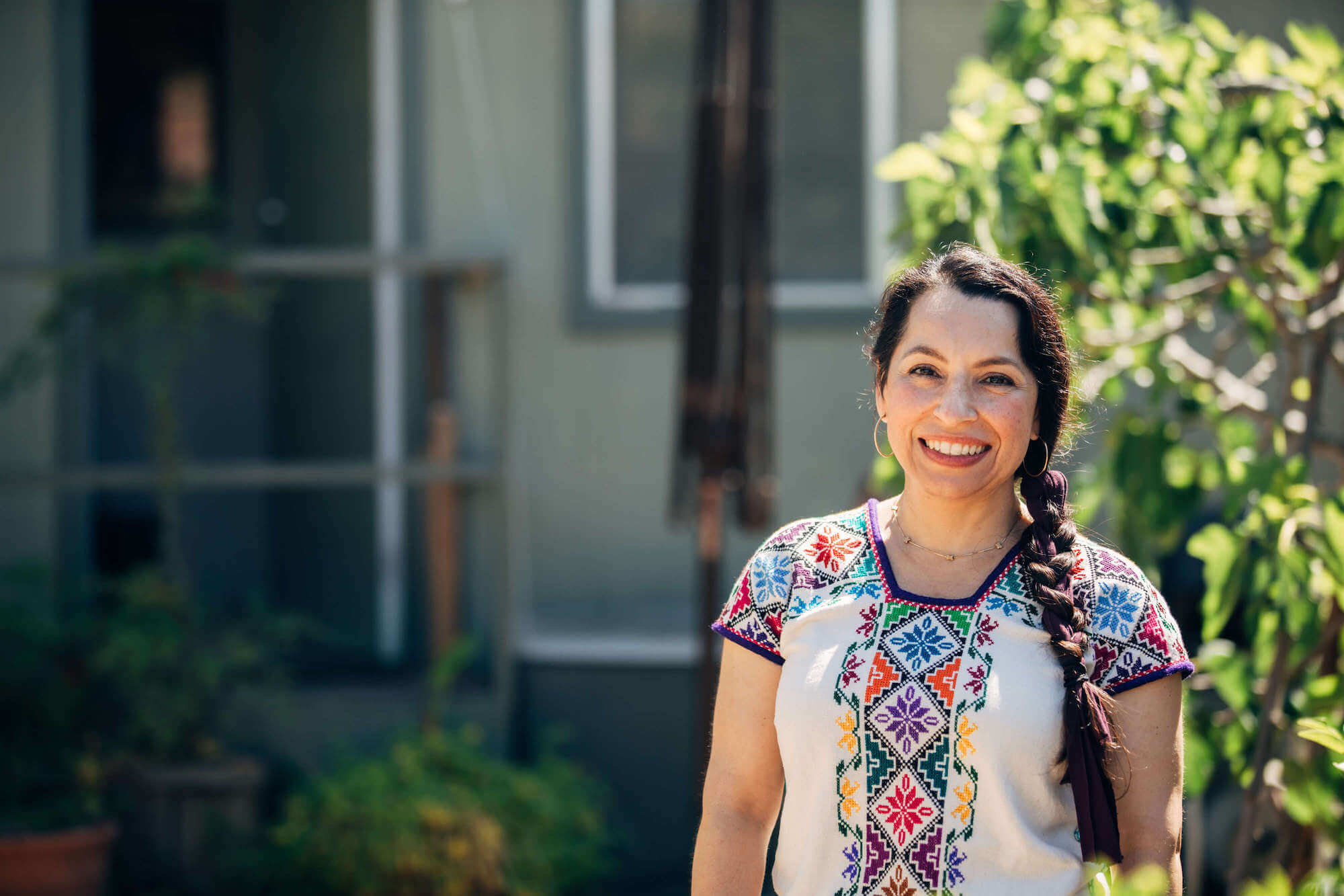 Smiling woman with home in background