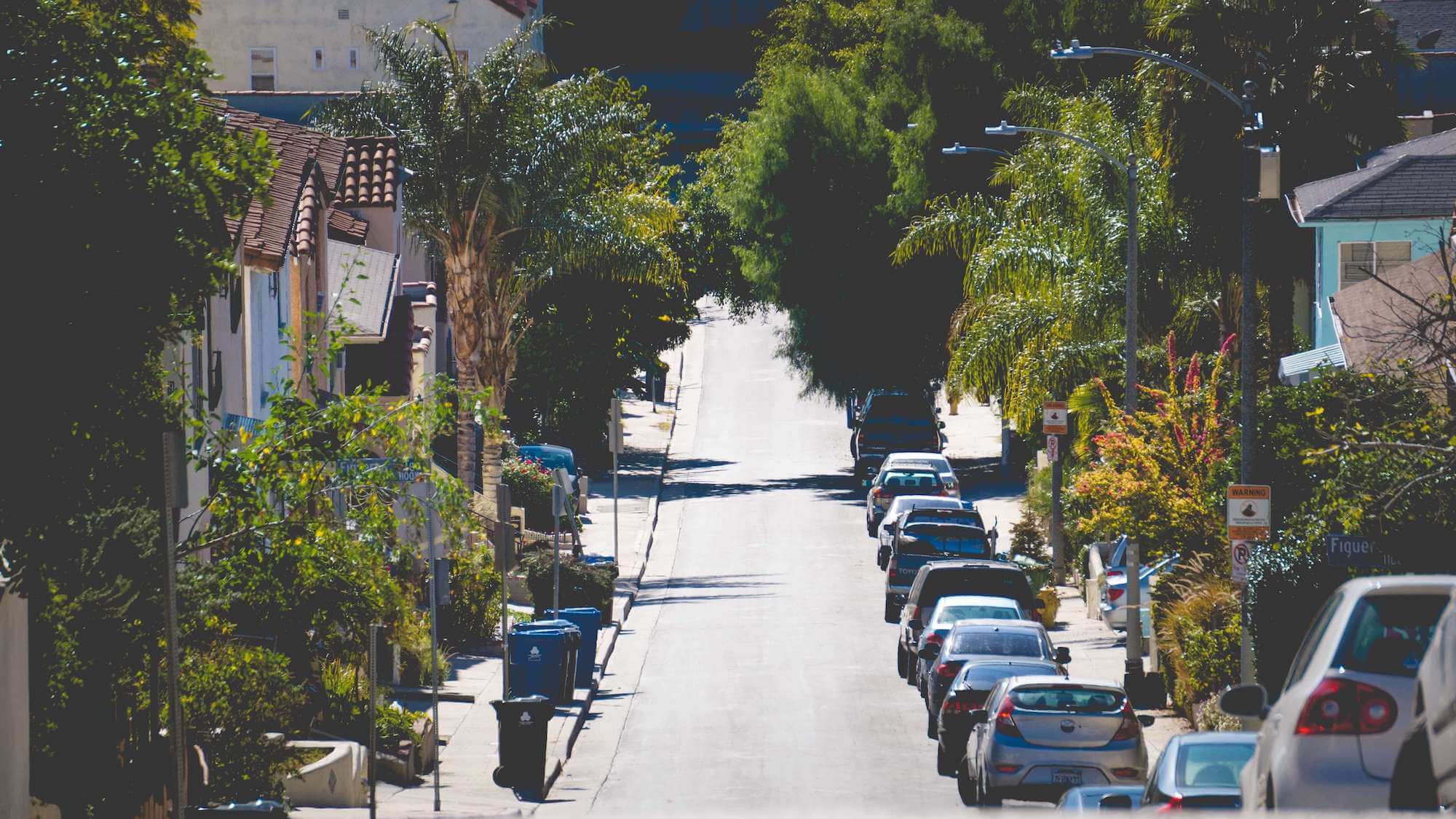 Photo of street with parked cars // De Andre Bush / unsplash.com